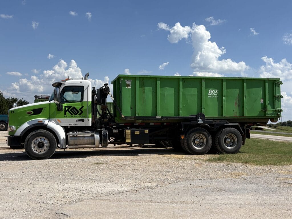 Truck ready to deliver roll off dumpster | Roll Off Solutions